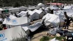 Un homme marche au milieu du camp de réfugiés à Moria, Grèce, 16 mars 2017. 