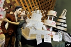 FILE - Figurines are depicted in an embrace as part of the wedding cake display at Masterpiece Cakeshop, Denver, Colorado, June 6, 2013.
