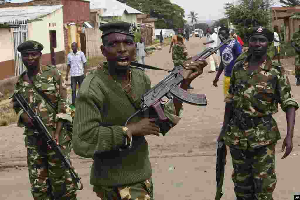 Des soldats tirent en l'air pour disperser des manifestants qui ont acculé Jean Claude Niyonzima un membre présumé de la milice Imbonerakure de la jeunesse du parti au pouvoir dans un égout dans le quartier de Cibitoke de Bujumbura, au Burundi, jeudi 7 mai 2015.