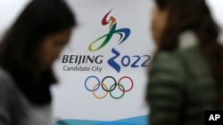 在北京申請主辦2022冬奧會海報前交談的記者（美聯社圖片）