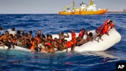 Des migrants appellent à l’aide à l’approche du bateau de sauvetage de l’ONG SOS Méditerranée près de l’ile de Lampedusa, Italie, 17 avril 2016.