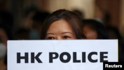 一名香港抗議者手舉“香港警察大規模性犯罪”的牌子在中環遮打花園舉行示威。（2019年10月11日）