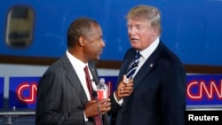 Le phlegmatique Dr. Ben Carson et le milliardaire Donald Trump échangent quelques mots pendant une pause publicitaire au cours du débat des candidats républicains (REUTERS/Lucy Nicholson)