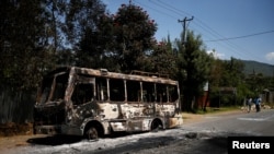 Quelques personnes passent devant un bus incendié lors des manifestations à Sebeta, dans la région d'Oromia, Ethiopie, 8 octobre 2016.