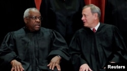 Le président de la Cour suprême des États-Unis, John Roberts (à dr.), discute avec le juge Clarence Thomas à Washington, États-Unis, le 30 novembre 2018.