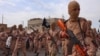 FILE -- In this photo released on April 25, 2015 by a militant website, which has been verified and is consistent with other AP reporting, young boys known as the "lion cubs" hold rifles during a parade after graduating from a religious school in Tal Afar