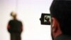 FILE - A police cameraman takes video footage of the hanging of a convicted murderer at Jamshidieh park in Tehran, Oct. 27, 2002.
