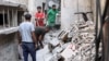 Men search through the rubble of the house of the sister of Ismail Haniyeh, the Doha-based political bureau chief of Hamas, after it was struck in the Shati camp west of Gaza City on June 25, 2024 . The Gaza civil defense agency said 10 members of Haniyeh's family were killed.