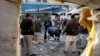 FILE - Pakistani security officials examine the site of a suicide attack in Mardan, Pakistan, Dec. 29, 2015.
