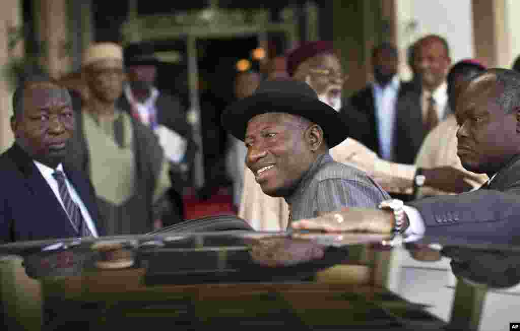 Le président nigérian Goodluck Jonathan, centre, monte dans son véhicule après le renouvellement de l’engagement pour des élections pacifiques, «libres, équitables et crédibles", avec le candidat d'opposition, le général Muhammadu Buhari, à Abuja, au Nigeria jeudi, 26 mars 2015. 