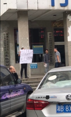 2019年10月22日，邱孝斌在湖南株洲三醫院門前舉牌聲援“潑墨女孩”董瑤瓊