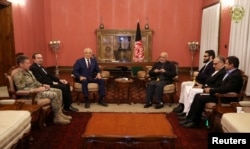 FILE - Afghanistan's President Ashraf Ghani, right, and U.S. special envoy for peace in Afghanistan, Zalmay Khalilzad, left, meet in Kabul, Nov.10, 2018.
