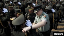 A Chinese army advisor puts rank on Cambodian army graduates during a graduation ceremony at Army Institute in Kampong Speu province, Cambodia, March 12, 2015.