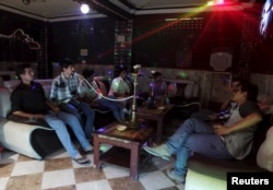 FILE - Afghan youths smoke shisha at a basement karaoke club in Mazar-i-Sharif June 1, 2015. Mazar-i-Sharif, the capital of Balkh province, is widely seen as one of a few oases of calm in the war-torn country.