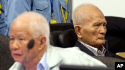 In this photo released by the Extraordinary Chambers in the Courts of Cambodia, Khieu Samphan, left, former Khmer Rouge head of state, and Nuon Chea, right, who was the Khmer Rouge's chief ideologist and No. 2 leader, sit in the court hall.