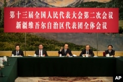 2019年3月12日在北京人民大會堂舉行的全國人大會議新疆維吾爾自治區代表團會議上，新疆黨委書記陳全國（中）講話。講台上的人前面都沒有名牌。
