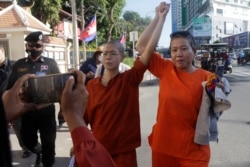 កញ្ញា សេង ធារី មេធាវីខ្មែរអាមេរិកាំង លើកដៃឡើងលើជាមួយអ្នកគាំទ្រអ្នកស្រី ខណៈអ្នកស្រីដើរនៅមុខសាលាដំបូងរាជធានីភ្នំពេញ នៅថ្ងៃទី ៤ ខែមករា ឆ្នាំ ២០២២។