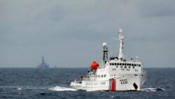 一艘中國海警船在南中國海上的一座中國海上鑽井平台旁駛過。（2014年6月13日）