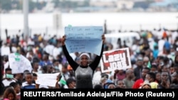 Une manifestante tient une pancarte lors d'une manifestation contre les brutalités policières à Lagos, au Nigeria, le 17 octobre 2020.