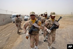 FILE - A group of Iranian border guards march at the eastern border of Iran shared with Pakistan, July 19, 2011.