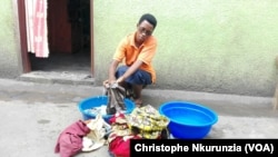 Godeberthe Hakizimana, la femme du journaliste Jean Bigirimana disparu est entrain de lessiver des habits, dans le quartier de Gituro à Kamenge au Nord de la capitale Bujumbura, Burundi, 22 février 2017. (VOA/Christophe Nkurunzia)