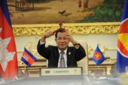 FILE -Cambodian Prime Minister Hun Sen holds the ceremonial gavel in a virtual meeting as Cambodia takes over the ASEAN chairmanship, from Brunei, for a third time, on Thursday, October 28, 2021. (Facebook/Samdech Hun Sen, Cambodian PM)