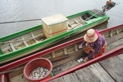 On a typical day, fishers in Bak Prea village dock their boats to sell some fish in front of fish dealer Pheav Soriya’s house. Fishers that VOA Khmer talks to say their catch is in decline, in Battambang province, on September 26, 2021. (Khan Sokummono/VOA Khmer)