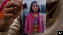 Mohammed Amin holds a picture of his daughter Zainab Ansari in Kasur, Pakistan, Jan. 18, 2018. The child whose horrific death enraged a nation and lifted the silence that surrounds child sexual abuse in the country.