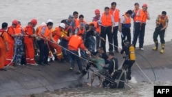 A 65-year-old woman, center, is rescued by divers from the Dongfangzhixing or "Eastern Star" vessel, which sank in the Yangtze river in Jianli, central China's Hubei province, June 2, 2015. 