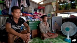 (រូបថត​ឯកសារ​) អតីត​ទាសករ​នេសាទ​ជនជាតិ​ភូមាលោក​ Kaung Htet Wai (រូបឆ្វេង)​ និង ​លោក Lin Lin​ អង្គុយ​ក្នុងបន្ទប់​តូចមួយ​ ក្នុងខ្ទម​​ក្នុងទីក្រុង​ Yangon ប្រទេស​មីយ៉ាន់ម៉ា​។