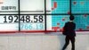 A man looks at an electronic stock board showing Japan's Nikkei 225 index at a securities firm in Tokyo Friday, Jan. 4, 2019. 