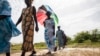 In this photo taken Oct. 19, 2015, women walk on farmlands that was destroyed by high salt content due to rising sea levels in Saloum Delta, Diamniadio Island in Senegal. Thousands of people on these tiny islands and villages in this part of West Africa are living on the frontline of climate change.