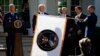 FILE- Gen. John "Jay" Raymond, President Trump, Vice President Pence, and Sec. of Defense Mark Esper, unfurl the U.S. Space Command flag during a ceremony to establishment of the U.S. Space Command in the Rose Garden of the White House, Aug. 29, 2019.