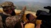 FILE - A Pakistan army officer points out the Indian forward area posts to journalists at Bagsar post on the Line of Control that divides Kashmir between Pakistan and India, Oct. 1, 2016. 