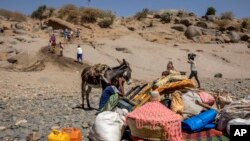 FILE - Wakimbizi waliokimbia vita mkoa wa Tigray na samani na punda wao katika eneo la bonde la mto Tekeze katika mpaka wa Sudan-Ethiopia, huko Hamdayet, mashariki ya Sudan, Nov. 21, 2020. 