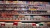 FILE - Cigarette packs are seen on shelves in a tobacco shop in Cagnes-sur-Mer, France, Sept. 8, 2015. The World Health Organization on Tuesday called on countries do adopt plain packaging to make tobacco products less attractive and reduce deaths from smoking.