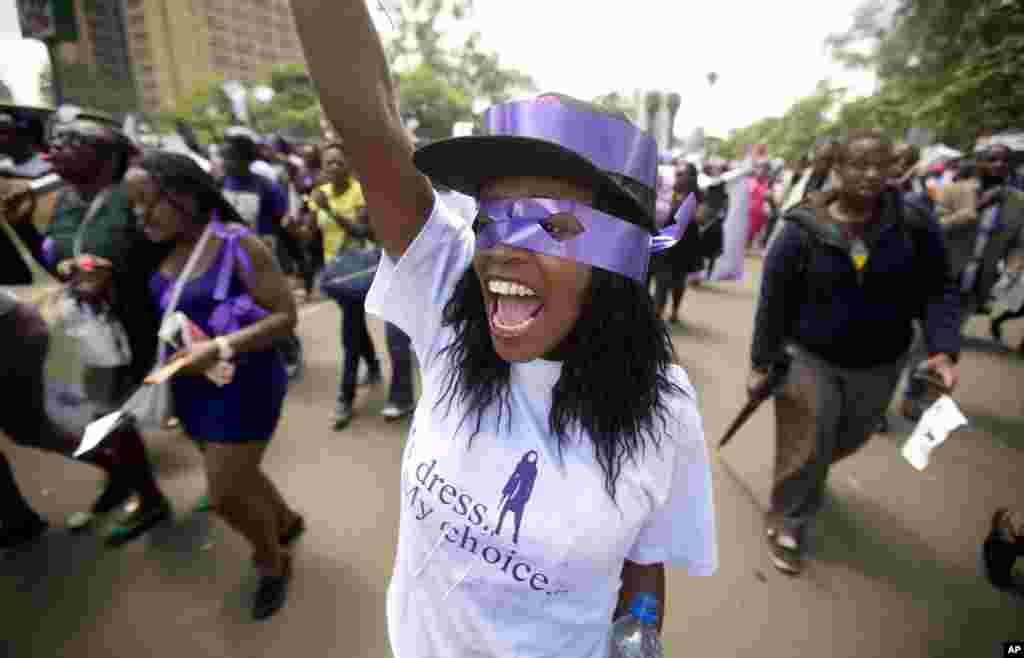 Une kenyane lève la main droite alors qu'elle manifeste avec un groupe d'autres femmes pour la liberté de porter les habits de leur choix, lundi 17 novembre 2014 à Nairobi, Kenya.