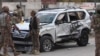 Pakistan paramilitary troops gather next to a damaged vehicle at the site of a suicide bombing in Quetta, Pakistan, Saturday, Nov. 25, 2017.