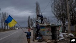 Згідно з опитуванням, 74% українців вважають, що Україна поверне всі свої території. На фото –українські діти, які граються на покинутому блокпосту в Херсоні, після відступу з міста російських окупаційних військ. Південна Україна, середа, 23 листопада 2022 року. (AP Photo)