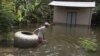A man pulls a giant jar in flood waters on a street in Kandal province, file photo. 