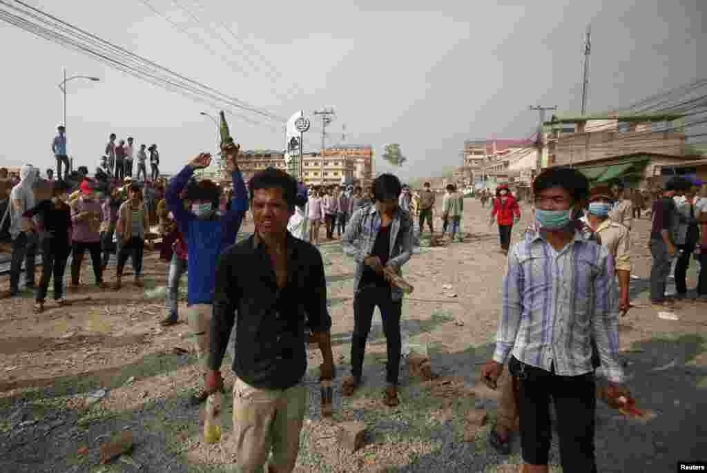 Garment workers hold gas bombs duing clashes with police in Phnom Penh, Jan. 3, 2014.