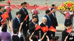 中國國家主席習近平和越南共產黨總書記阮富仲前往參加會談，向歡迎群眾招手（2017年11月12日）