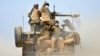 Shi'ite fighters ride on a military vehicle heading toward the airport of Tal Afar during a battle with Islamic State militants in Tal Afar, Iraq, Nov. 16, 2016. 