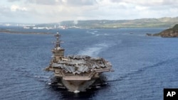 資料照片：在2020年6月4日美國海軍提供的照片中，「西奧多·羅斯福號」航空母艦離開關島的阿普拉港。 (美聯社照片)