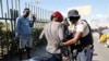 FILE - A police officer pats down a motorcyclist at a checkpoint in Port-au-Prince, Haiti, Jan. 26, 2024. A court in Kenya on Friday blocked the deployment of a U.N.-backed police force to help fight gangs in the troubled Caribbean country. 