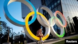 日本東京奧林匹克博物館前一個兒童在奧運五環上玩耍。 （2020年2月17日）
