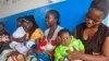 FILE - In this photo taken Nov. 3, 2014, mothers wait inline for their children to be vaccinated by heath workers at the Pipeline Community Health Center, situated on the outskirts of Monrovia, Liberia. 