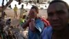 FILE - An illegal immigrant from Ethiopia covers his face as he waits with others for a boat to cross into Yemen outside the town of Obock, north Djibouti. 