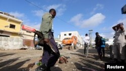 Un soldat somalien gardent les corps des victimes de l'attaque à la voiture piégée revendiquée par les shebab près de l'hôtel Nasahablood à Mogadiscio en Somalie, le 26 juin 2016. REUTERS/Feisal OmarTEMPLATE