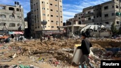 Palestinians inspect damages following an Israeli raid at Kamal Adwan hospital in the northern Gaza Strip